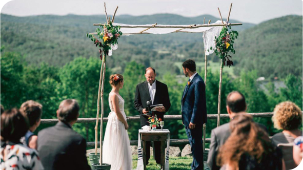A couple at the altar at an outdoor wedding.