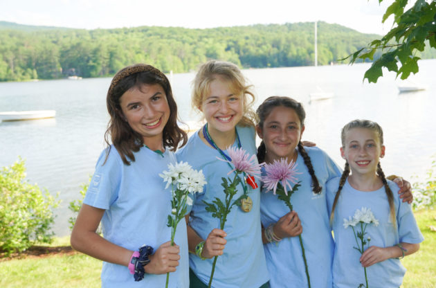 Four Hivers standing together holding flowers.