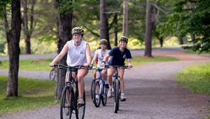 A group of campers biking on a trail.