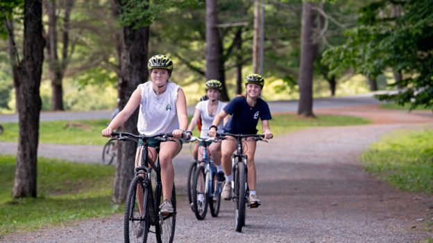 A group of campers biking on a trail.
