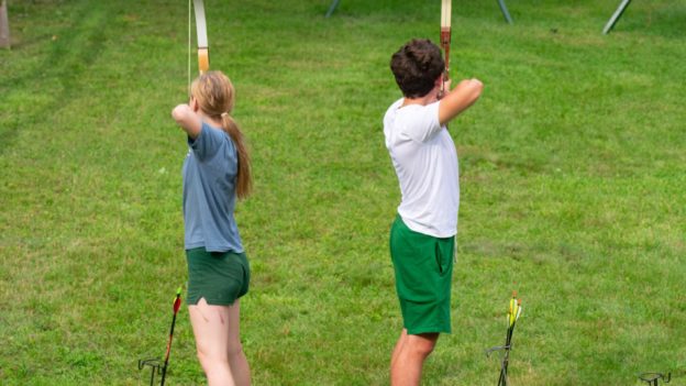 Campers shooting arrows on the archery range.
