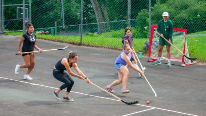 Campers playing street hockey.