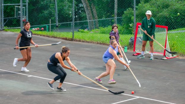 Campers playing street hockey.