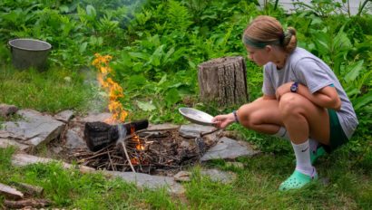 A camper cooking over a campfire.
