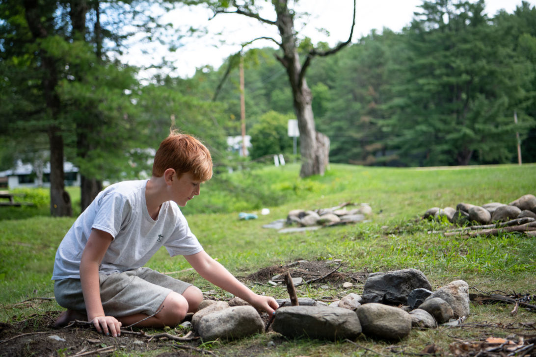A campers learning how to build a fire.