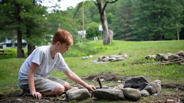 A campers learning how to build a fire.