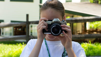 A camper looking through a film camera.