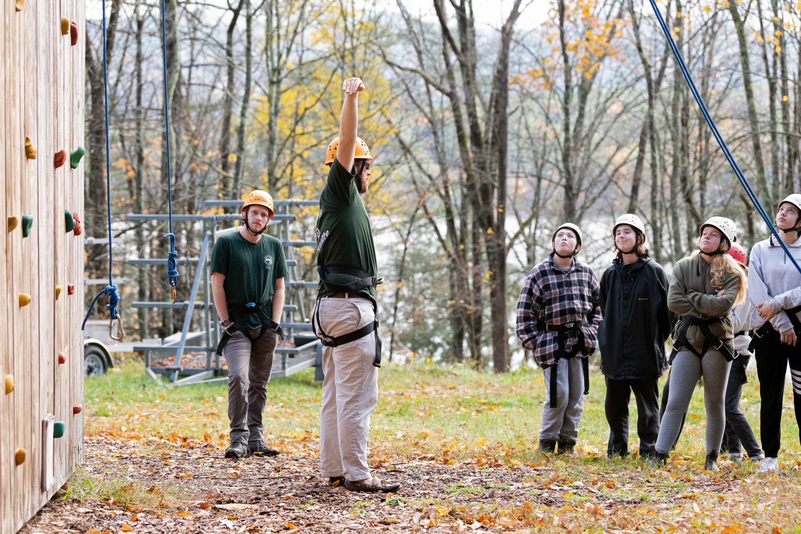 A rock climbing instructor speaking in front of campers.