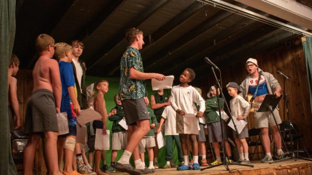 Campers performing a funny skit at an assembly.