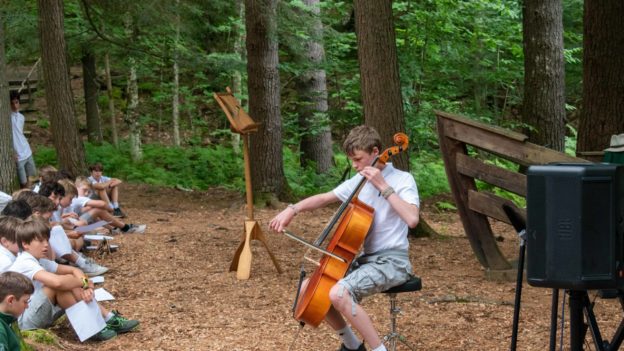 A camper playing the cello for the camp at chapel.