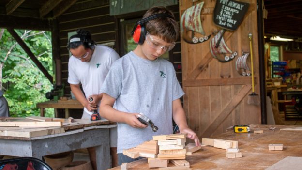 Campers learning woodworking.