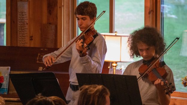 Two campers playing violin.