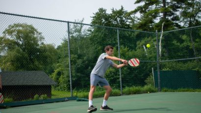 A counselor playing pickle ball on Lanakila's tennis courts.