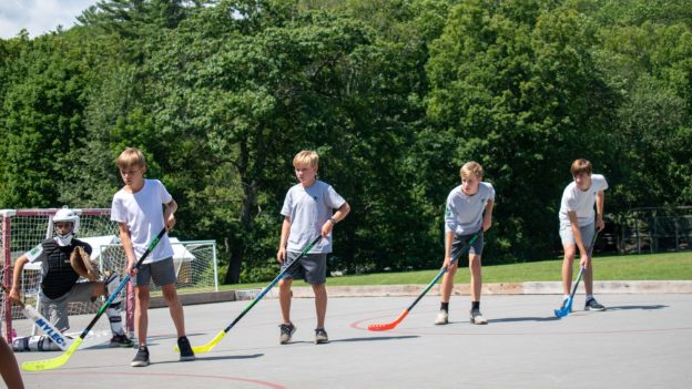 Campers playing street hockey.