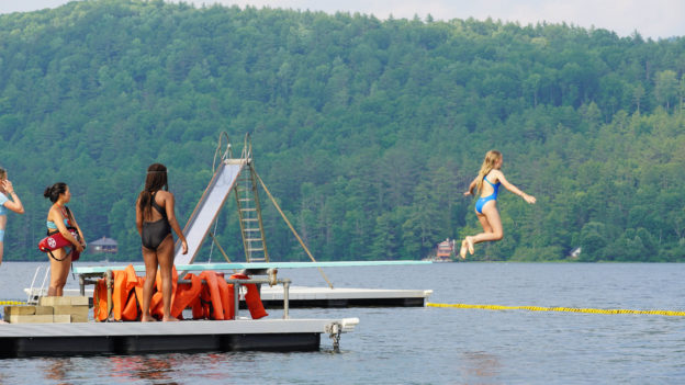 Campers diving off the dock.