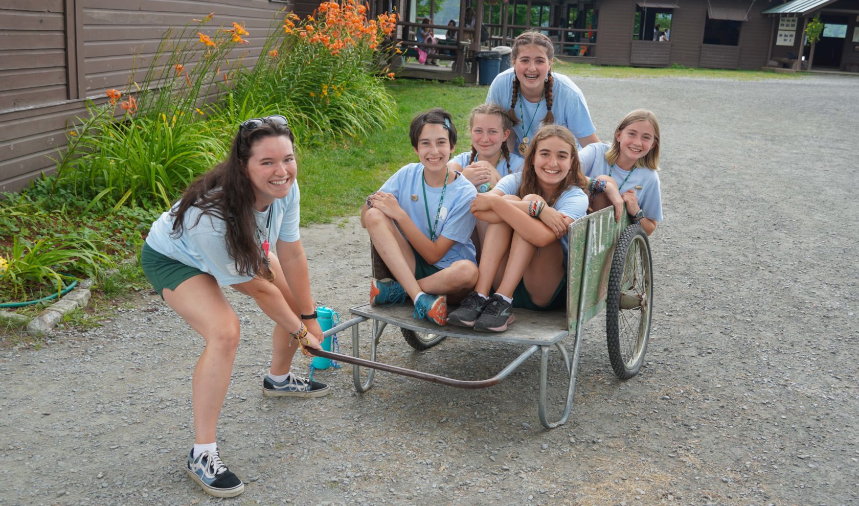 Campers sitting in a wheelbarrow.