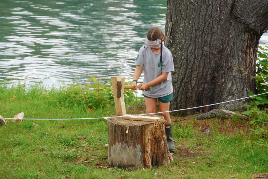 Hive camper chopping wood.