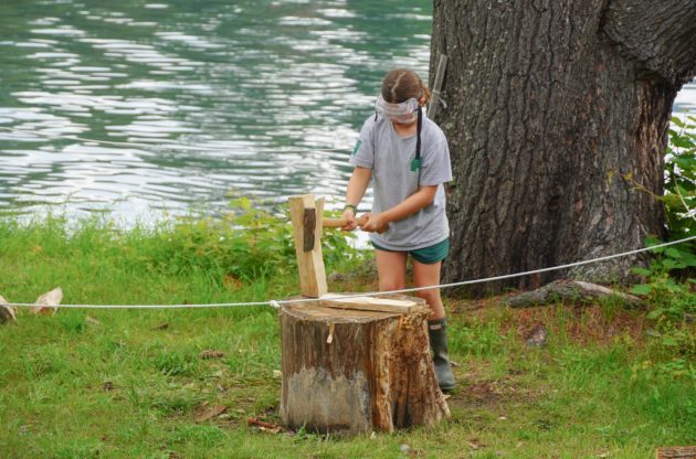 Hive camper chopping wood.