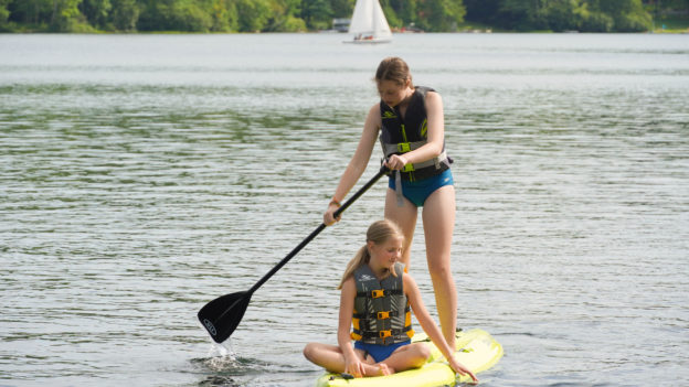 Two campers on a paddleboard.