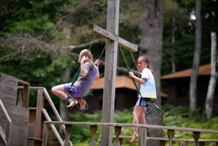 Two young Horizons campers swinging on the pirate ship.