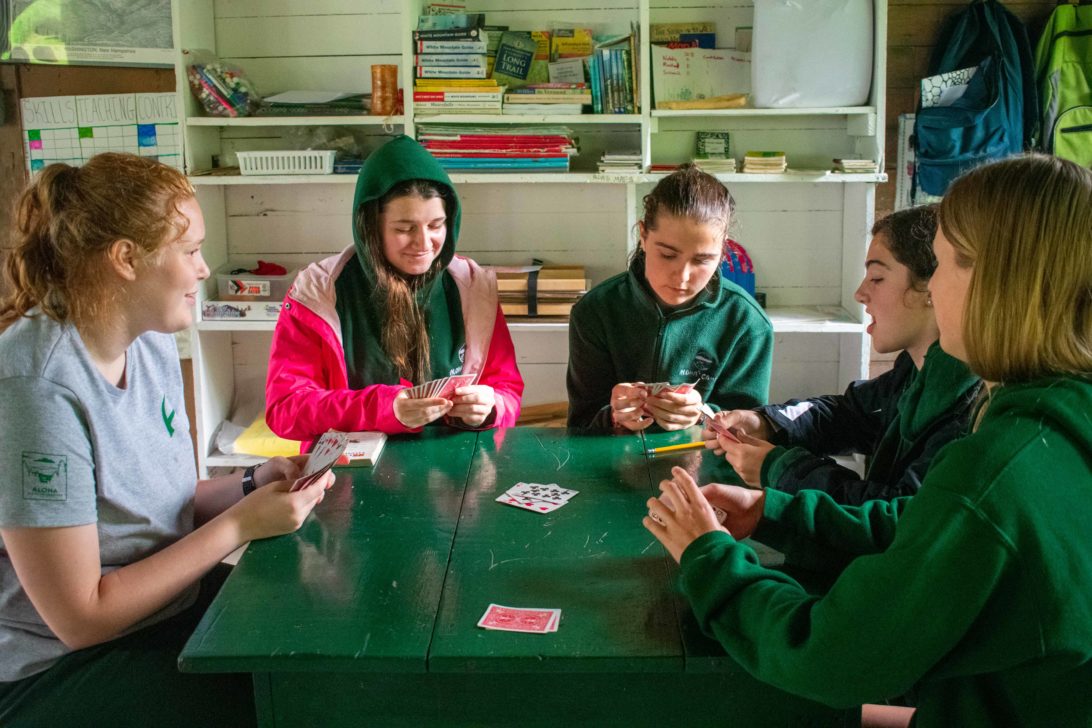 A group of campers playing card games.