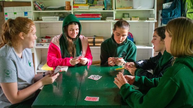 A group of campers playing card games.