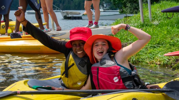 Two campers on their own kayaks, posing together.