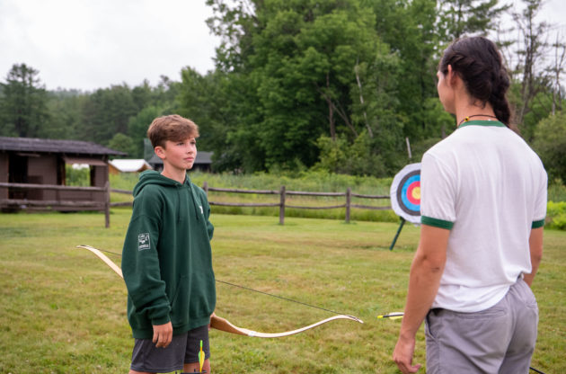 Campers learning how to shoot a bow and arrow.