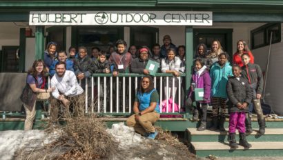 A school group and Hulbert staff gathered on the front porch of The Hulbert Outdoor Center.