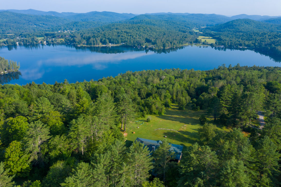 A bird's eye view including the forest and lake of Ohana's campus.