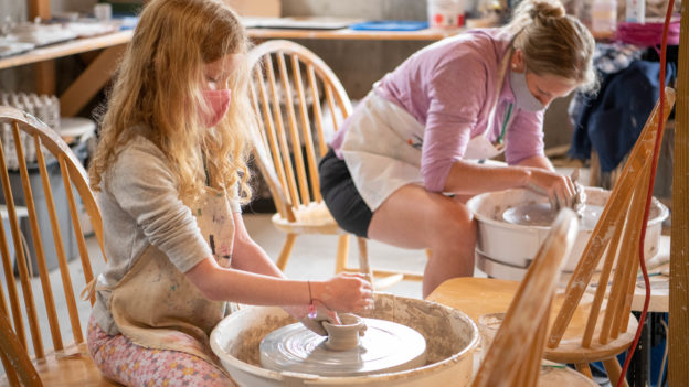 A young camper doing pottery.