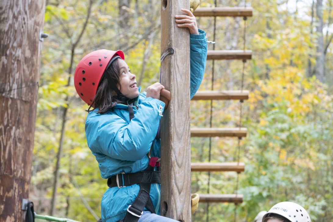 A Hulbert student climbing an obstacle course.