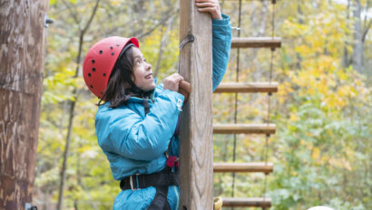 A Hulbert student climbing an obstacle course.