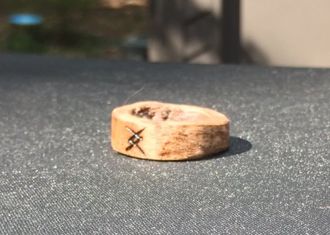 A wooden ring that's been wood burned.