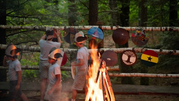 Campers around the bonfire hanging their viking shields.