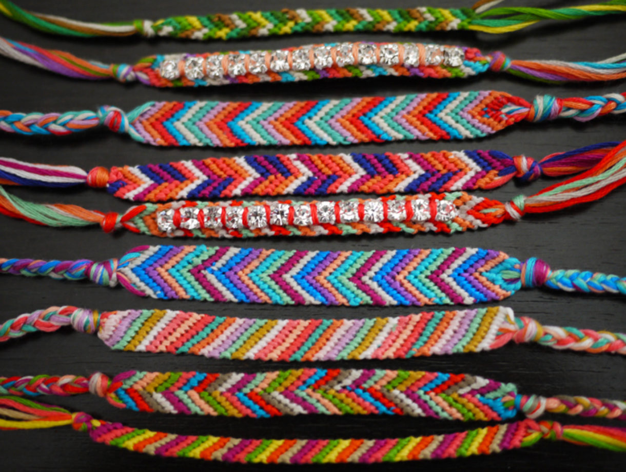 Nine colorful friendship bracelets lined up.