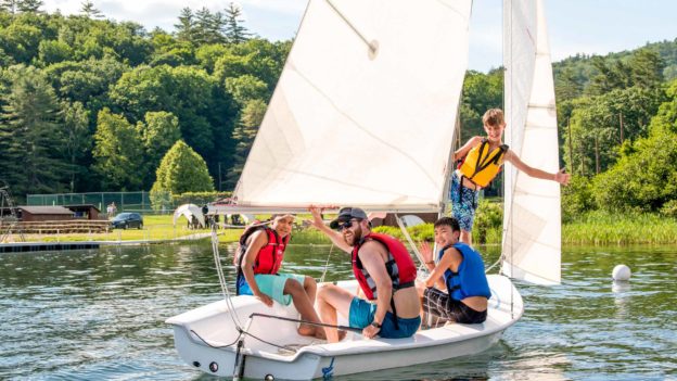 Lanakila campers and a counselor on a sailboat.