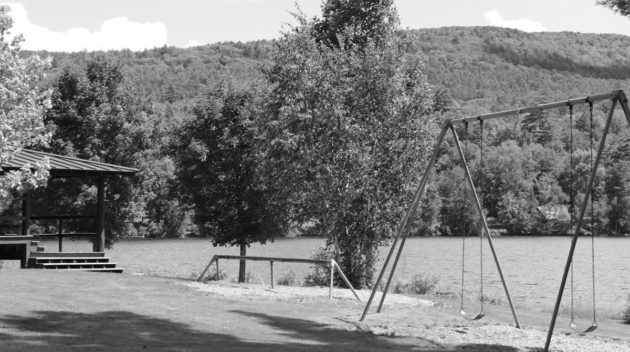 A black and white view of a swing set.