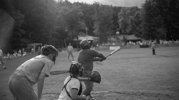 A black and white view of people playing baseball.
