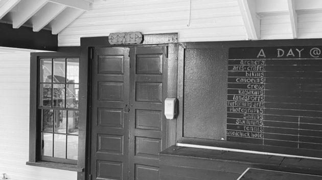 A black and white view of a door and a chalkboard.