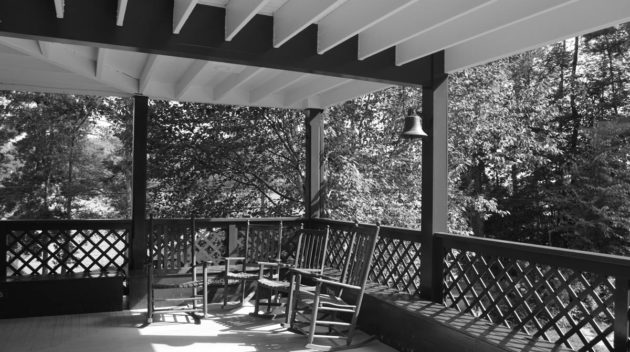 A black and white view of a porch.