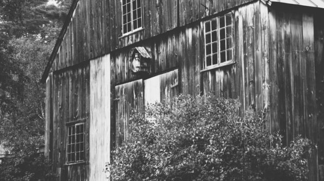 A black and white view of a barn.
