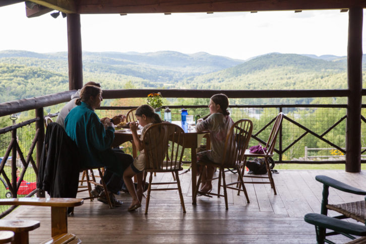 A family having a meal together on a porch.