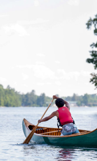 A camper soloing a canoe.