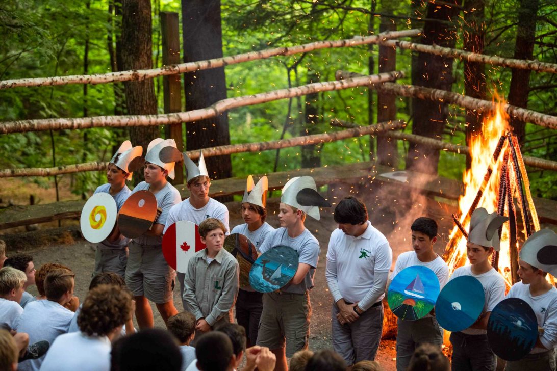 A group of campers in front of a campfire receiving their viking honors..